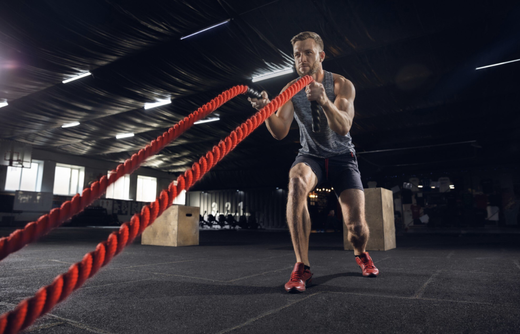 a man exercising with ropes in an indoor gym